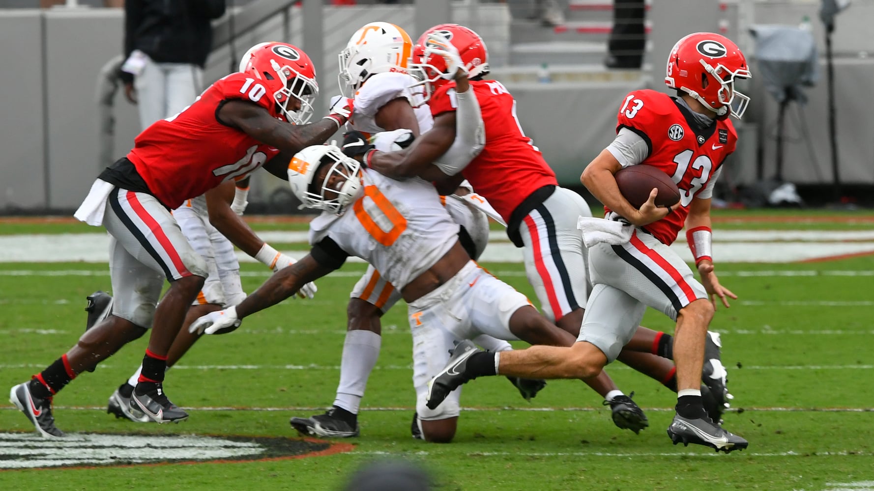 Georgia quarterback Stetson Bennett (13) runs as Tennessee defensive back Bryce Thompson (0) is layed out with a block during the second half of a football game Saturday, Oct. 10, 2020, at Sanford Stadium in Athens. Georgia won 44-21. JOHN AMIS FOR THE ATLANTA JOURNAL- CONSTITUTION