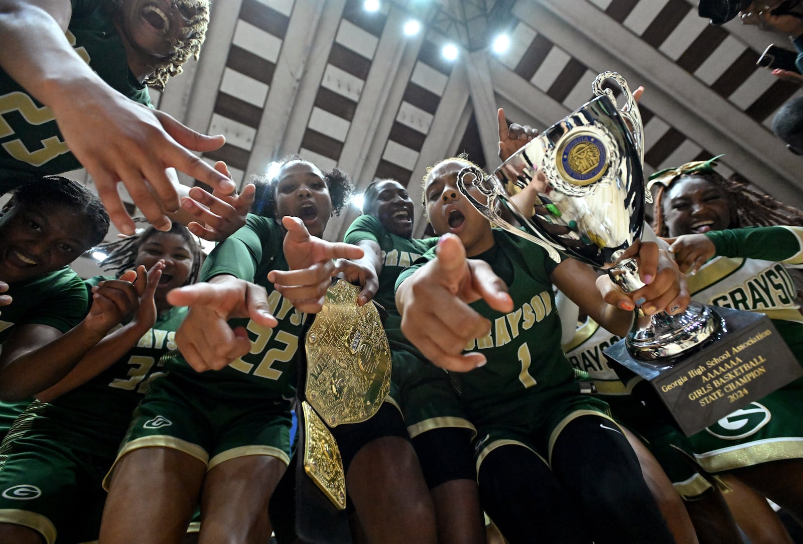 Grayson's Malaya Jones holds the trophy while celebrating with teammates and cheerleaders during GHSA Basketball Class 7A girl’s state championship game at the Macon Centreplex.