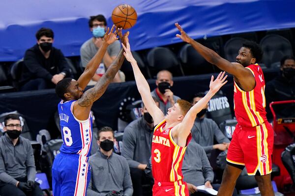 Philadelphia 76ers' Shake Milton, left, goes up for a shot against Atlanta Hawks' Kevin Huerter, center, and Solomon Hill during the second half of Game 2 in a second-round NBA basketball playoff series, Tuesday, June 8, 2021, in Philadelphia. (AP Photo/Matt Slocum)