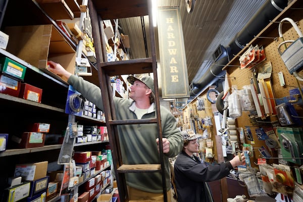 Chandler and Gavin Breedlove are seen organizing merchandise at the Rutledge Hardware store on Tuesday, March 19, 2023. Rutledge is the nearest town to the construction of the Rivian plant; the corporation announced last week its plans to halt construction on the Georgia site. Miguel Martinez /miguel.martinezjimenez@ajc.com