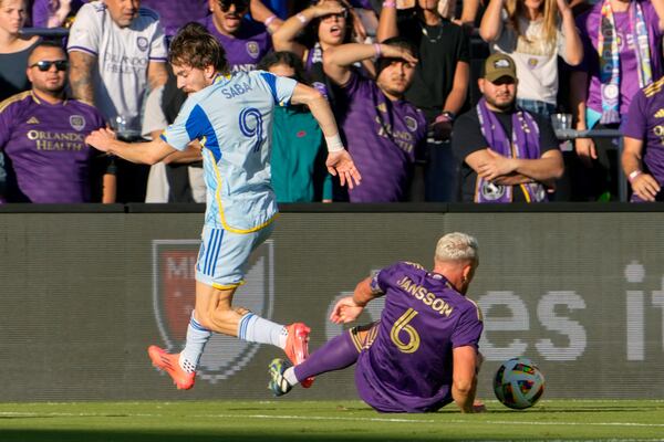 Orlando City's Robin Jansson (6) steals the ball from Atlanta United's Saba Lobzhanidze (9) during the first half of an MLS Semifinal Conference playoff soccer match, Sunday, Nov. 24, 2024, in Orlando, Fla. (AP Photo/John Raoux)