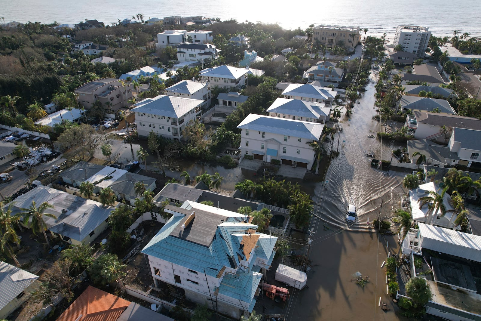 A truck drives down a flooded street in Siesta Key, Fla., following the passage of Hurricane Milton, Thursday, Oct. 10, 2024. (AP Photo/Rebecca Blackwell)