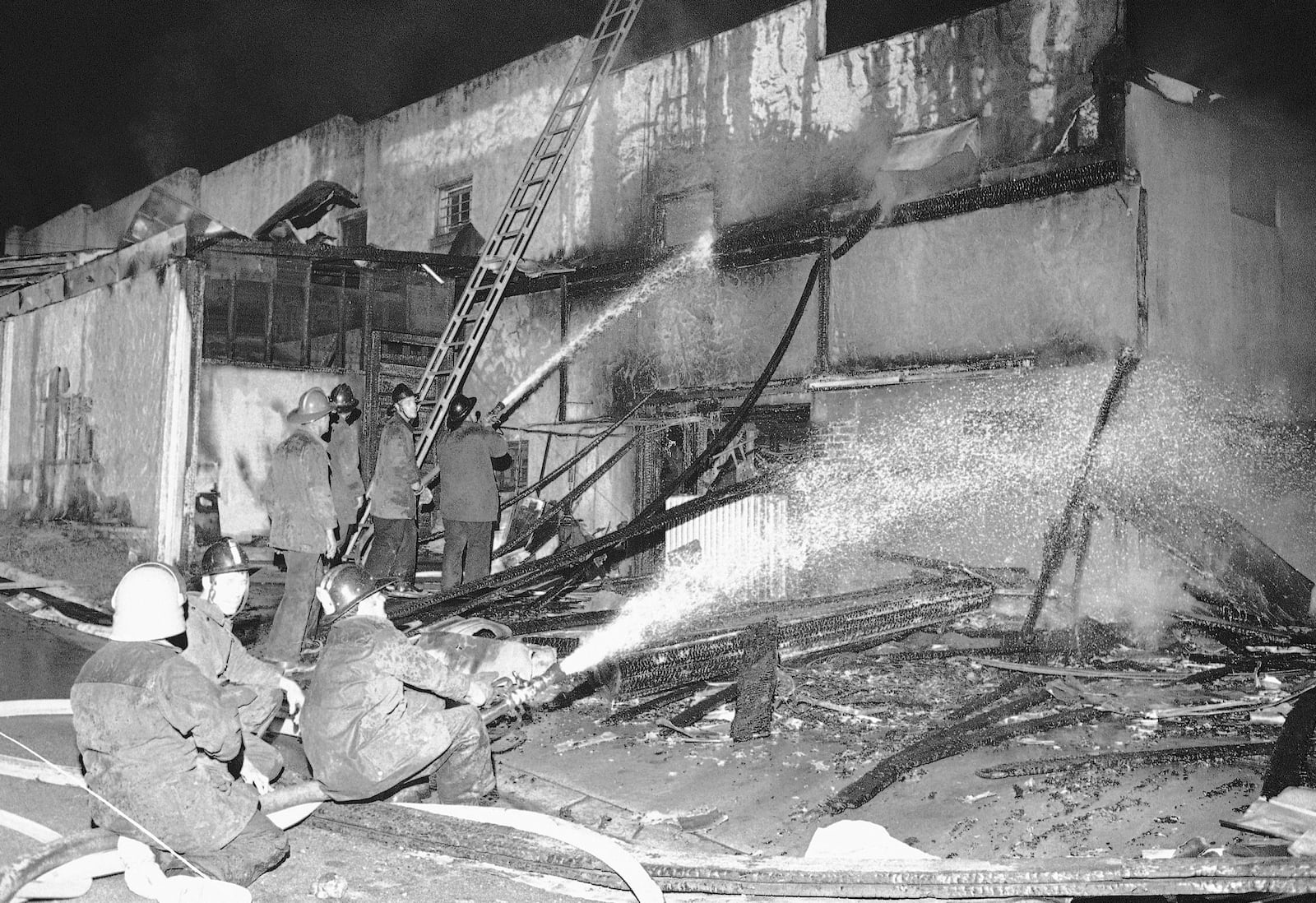 Firemen spray a stream of water on the burned-out shell of a grocery store in Augusta, Ga., May 12, 1970. This was one of more than fifty fires which were set by roving mobs. Five persons have been reported dead. (AP Photo/Joe Holloway, Jr.)