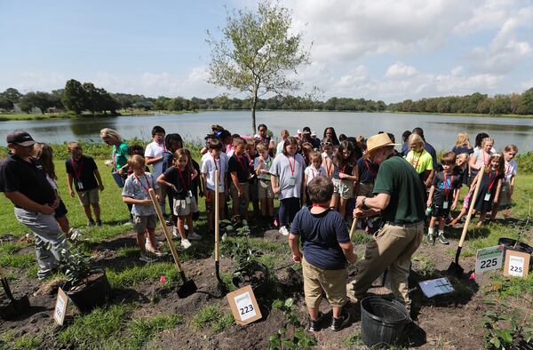 Dr. Sidney Smith shows a group of students how to plant a Camellia on Thursday, October 6, 2023 at Lake Mayer.