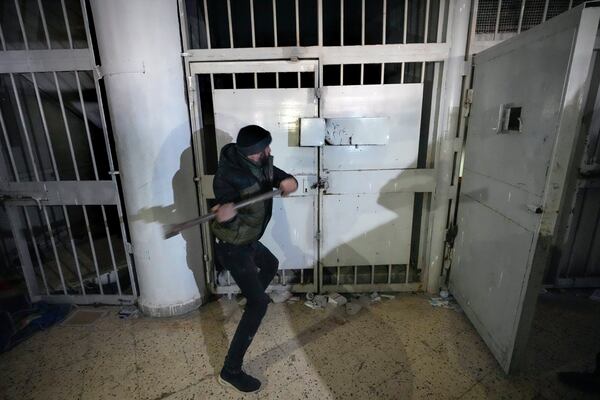 A man breaks the lock of a cell in the infamous Saydnaya military prison, just north of Damascus, Syria, Monday, Dec. 9, 2024. Crowds are gathering to enter the prison, known as the "human slaughterhouse," after thousands of inmates were released following the rebels' overthrow of Bashar al-Assad's regime on Sunday. (AP Photo/Hussein Malla)