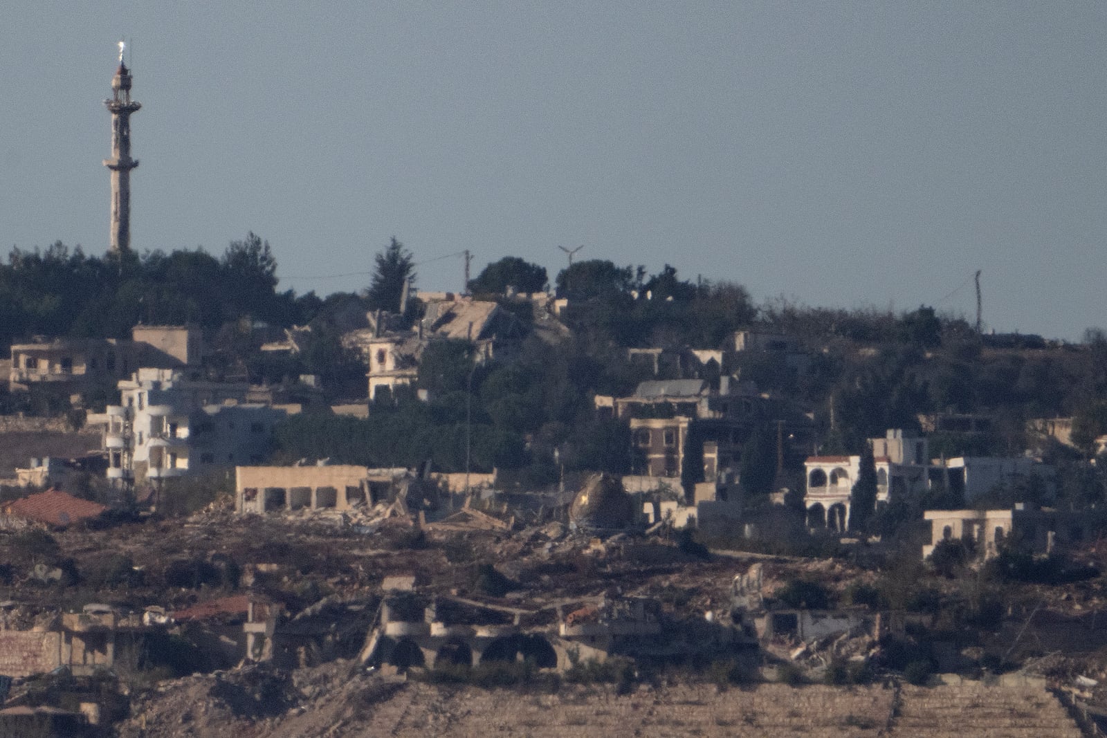 Destroyed buildings stand in an area in southern Lebanon as seen from northern Israel, Tuesday, Oct. 8, 2024. (AP Photo/Leo Correa)