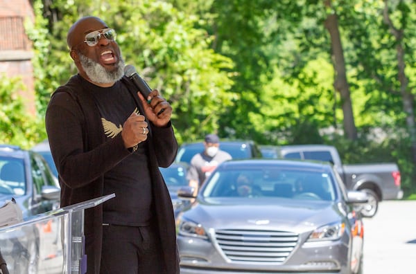 New Beginning Full Gospel Baptist Church Worship Leader Demetrius Banks talks to the church members in there cars during the drive-in Sunday service on May 3, 2020. STEVE SCHAEFER / SPECIAL TO THE AJC