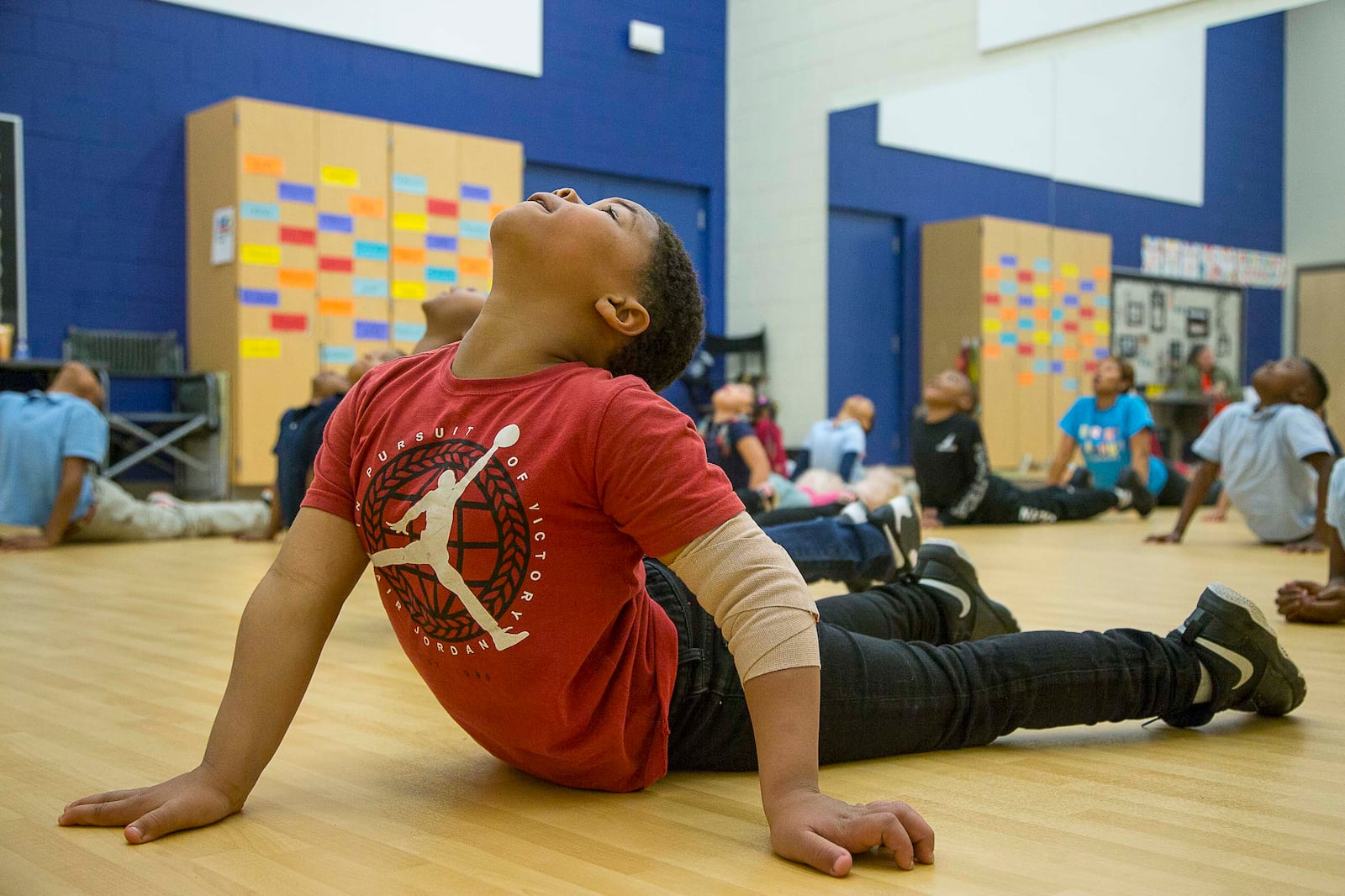 Harper-Archer Elementary School second grader Jacquez Slaton stretches his body alongside his peers at the start of dance class with dance teacher Lisa Perrymond inside the school's dance studio, Wednesday, January 29, 2020. Perrymond starts each class with deep breathing and extensive stretching. (ALYSSA POINTER/ALYSSA.POINTER@AJC.COM)