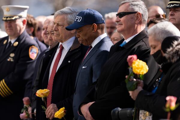 New York Mayor Eric Adams holds a flower and listens to speakers during a ceremony marking the anniversary of the 1993 World Trade Center bombing at the 9/11 Memorial, Wednesday, Feb. 26, 2025, in New York. (AP Photo/John Minchillo)