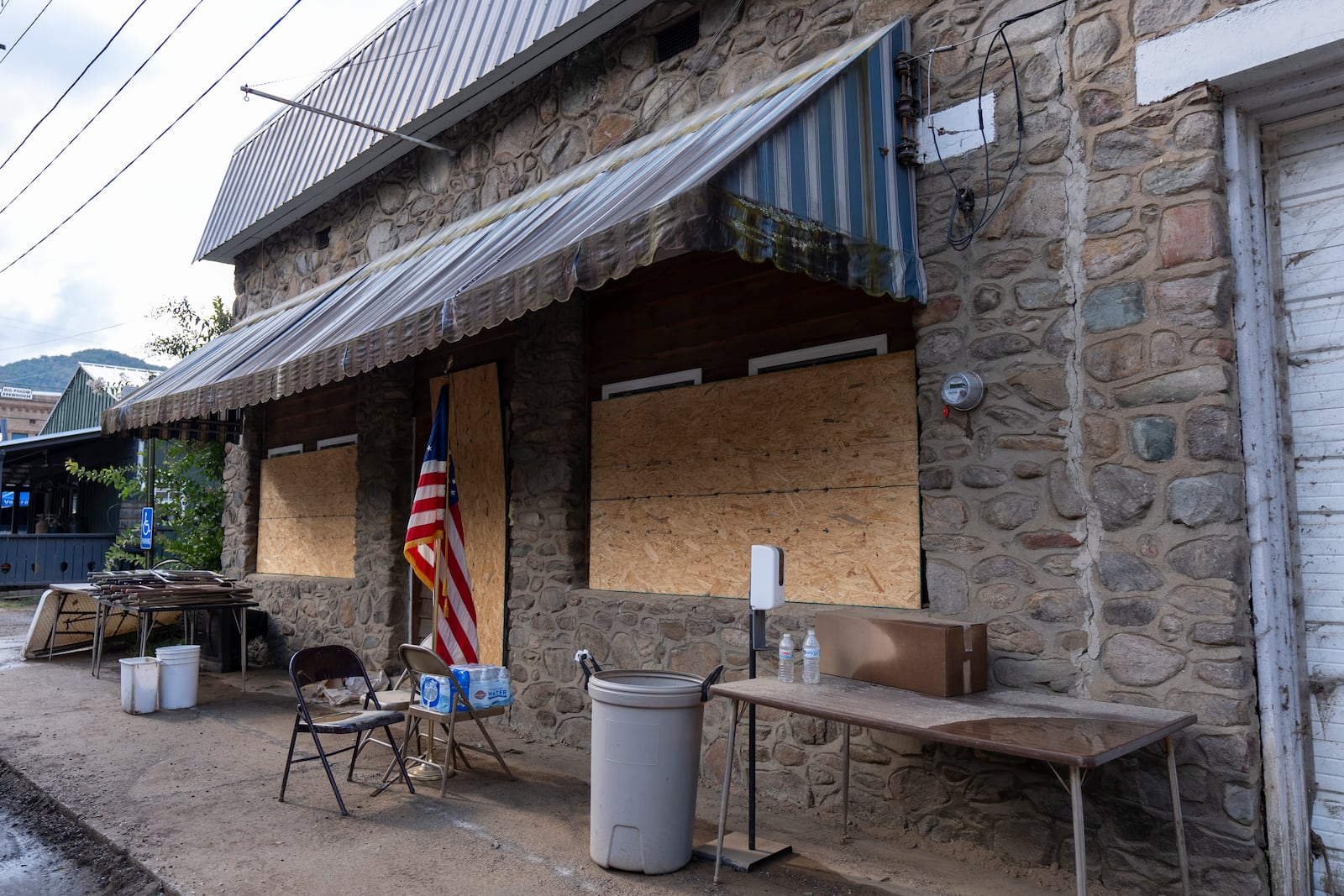 An American flag is seen outside of the Hot Springs Community Center, which is boarded up in the aftermath of Hurricane Helene due to water inundation damage, on Oct. 16, 2024, in Hot Springs, N.C. (AP Photo/Stephanie Scarbrough)