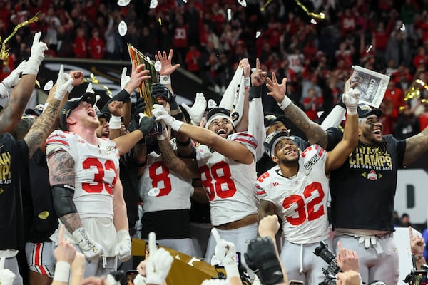 Ohio State players celebrate with their shiny new trophy.