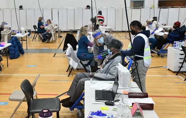 Registered Nurse Kathy Martin (center) prepares to administer a COVID-19 vaccine to Arthur Smith at Phoebe Healthworks in Albany on Wednesday. (Hyosub Shin / Hyosub.Shin@ajc.com)