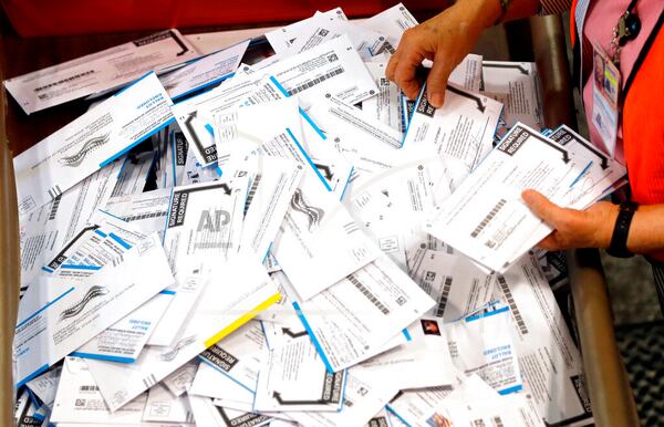 FILE - In this May 17, 2016, file photo, ballots are prepared for counting at Multnomah County election headquarters in Portland, Ore. The coronavirus has knocked presidential primaries back several weeks as officials worry about voters crowding into polling places. If the disease remains a hazard in November, Democrats say there's only one solution to preserve the November election, national voting by mail. (AP Photo/Don Ryan, File)