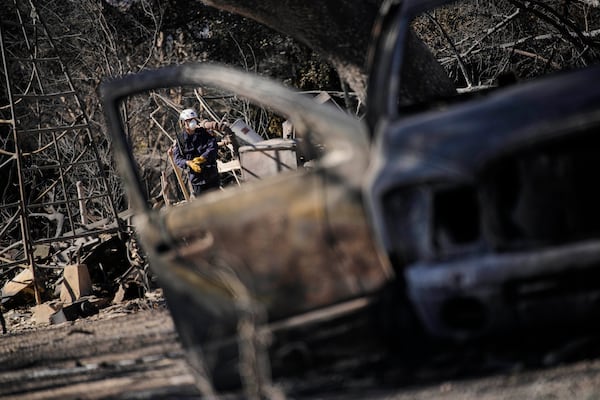 A search and rescue worker sifts through the wreckage of a home destroyed by the Eaton Fire, Tuesday, Jan. 14, 2025, in Altadena, Calif. (AP Photo/John Locher)