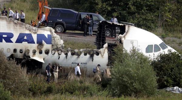 FILE - Inspectors evaluate the site of an Air France Airbus A340 plane that slid off the runway and crashed at Toronto Pearson International Airport in Toronto, Canada Wednesday, Aug. 3, 2005. (AP Photo/David Duprey, File)