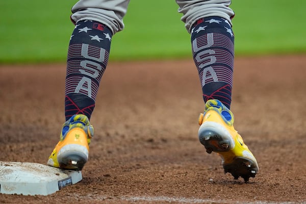 Atlanta Braves' Ronald Acuna Jr. stands at first base while wearing USA socks during the fifth inning of the team's baseball game against the Cleveland Guardians, Tuesday, July 4, 2023, in Cleveland. (AP Photo/Sue Ogrocki)