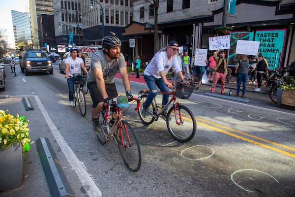 
Bike riders try to slow down the traffic on Peachtree St NE during a protest of the removal of the 'shared streets' in Atlanta Monday, March 14, 2022.  STEVE SCHAEFER FOR THE ATLANTA JOURNAL-CONSTITUTION