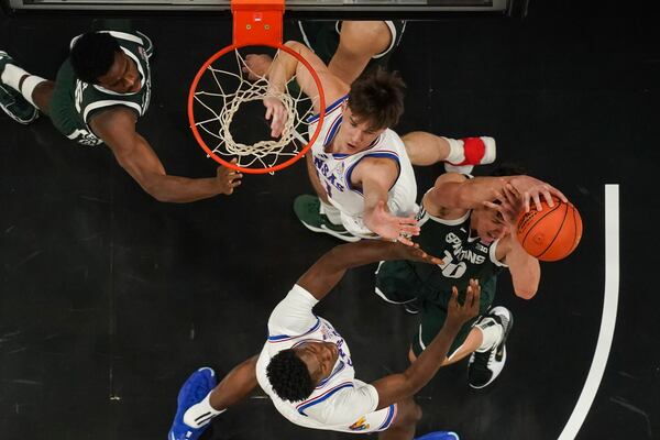 Michigan State center Szymon Zapala (10) battles Kansas' Zach Clemence (41) and Flory Bidunga (40) for a rebound during the first half of an NCAA college basketball game, Tuesday, Nov. 12, 2024, in Atlanta. (AP Photo/John Bazemore )