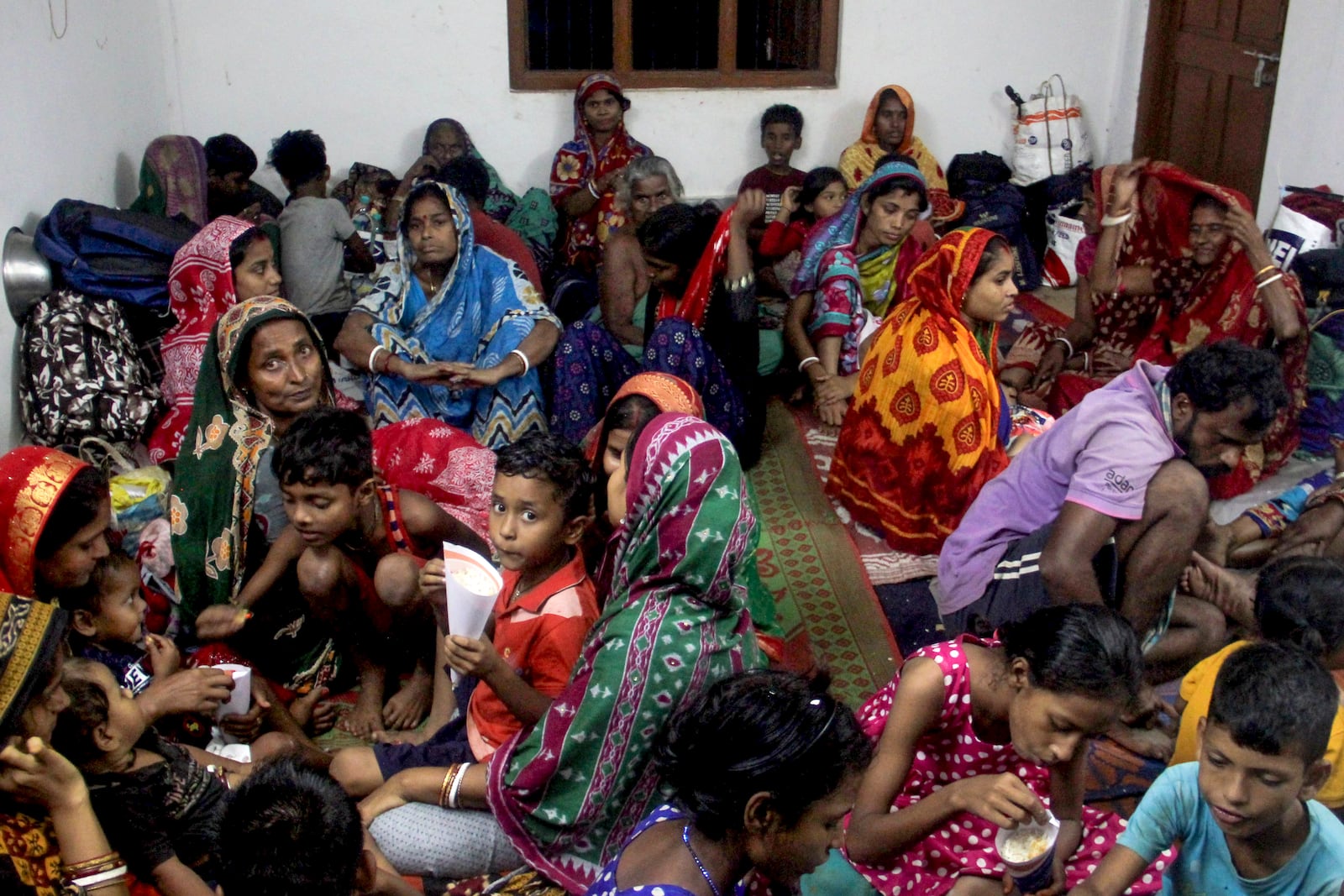 Evacuated families sit in a shelter in Dhamra town, on the coast of Bay of Bengal in Bhadrak district of Odisha state, on India's eastern coastline, where Tropical Storm Dana made landfall late Thursday night, according to the Indian Meteorological Department, India, Friday, Oct. 25, 2024. (AP Photo)