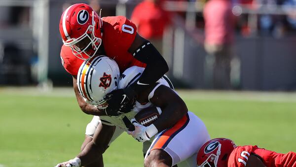 Georgia inside linebackers Rian Davis (left) and Jamon Dumas-Johnson tackle  Auburn running back Tank Bigsby for no gain at the line of scrimmage during the first quarter in a NCAA college football game on Saturday, Oct. 8, 2022, in Athens.  Curtis Compton / Curtis Compton@ajc.com