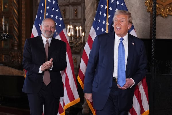 President-elect Donald Trump departs a news conference at Mar-a-Lago, Monday, Dec. 16, 2024, in Palm Beach, Fla., followed by Commerce Secretary nominee Howard Lutnick. (AP Photo/Evan Vucci)