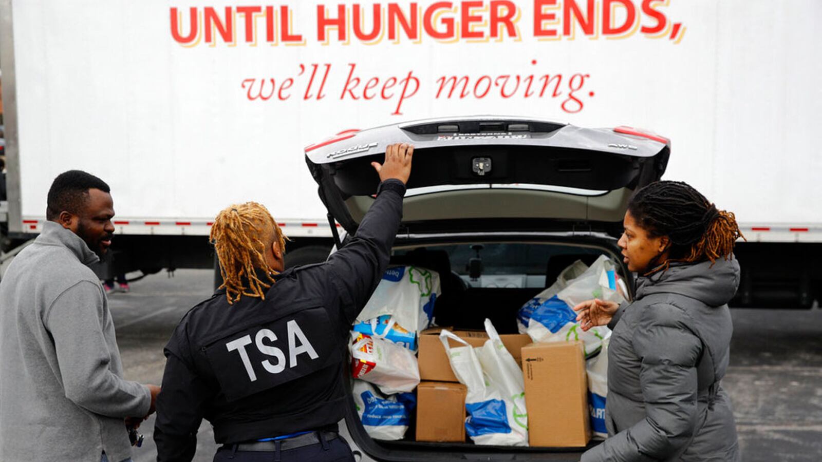 TSA employee Princess Young, center, loads food into a car after visiting a food pantry for furloughed government workers affected by the federal shutdown, Wednesday, Jan. 23, 2019, in Baltimore.