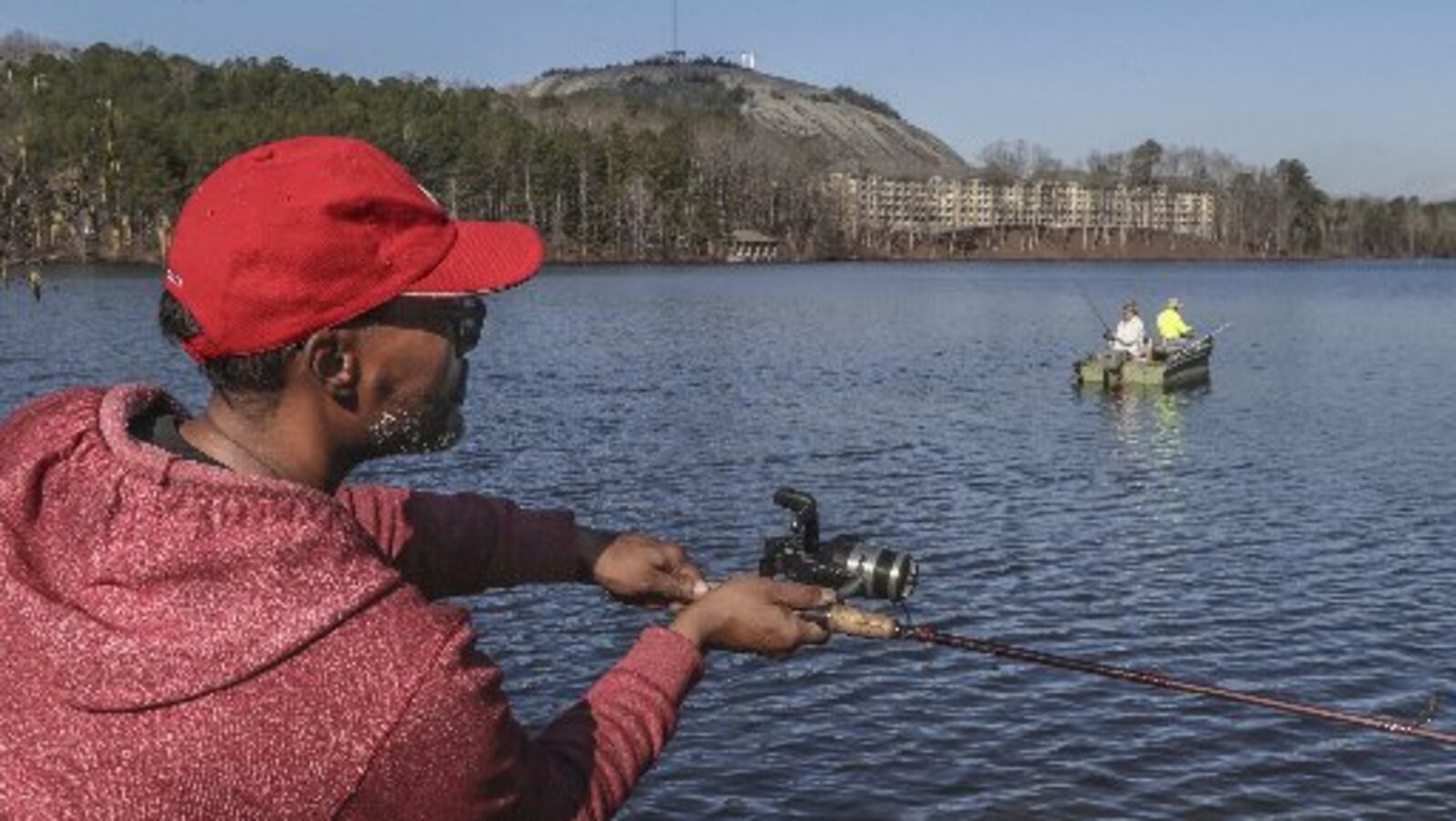 Derrick Monroe casts out onto Stone Mountain Lake on Thursday as temperatures continued to rise. JOHN SPINK / JSPINK@AJC.COM