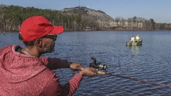 Derrick Monroe casts out onto Stone Mountain Lake on Thursday as temperatures continued to rise. JOHN SPINK / JSPINK@AJC.COM