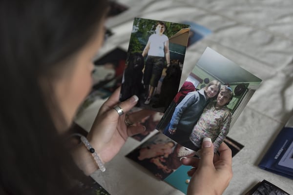 Amy Damera holds photos of her birth mother during a meeting with her sister Katalina Jones (not pictured) in Gainesville on May 5. Damera and Jones were each put up for adoption in Romania as children. For years, they have lived within miles of each other in Georgia, but they didn’t discover that until recently. DAVID BARNES / DAVID.BARNES@AJC.COM