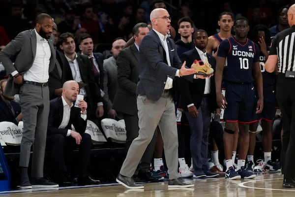 UConn head coach Dan Hurley, center, holds a shoe of St. John's Aaron Scott during the second half of an NCAA college basketball game, Sunday, Feb. 23, 2025, in New York. (AP Photo/Seth Wenig)