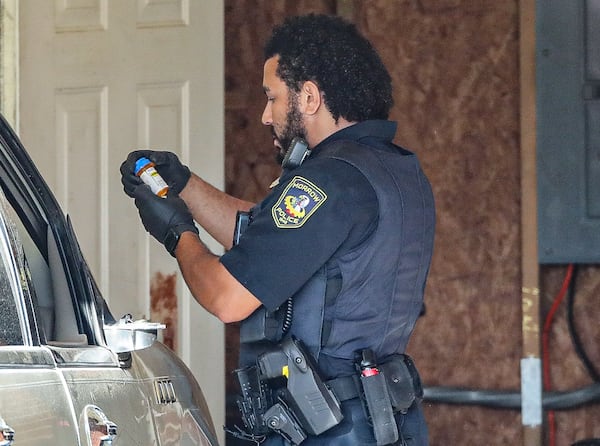 A Morrow officer catalogs suspected drugs Wednesday morning.