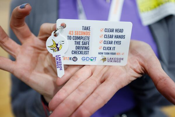 Marielena Gutierrez from GA Safe Routes to School shows a card with a key made by the Lutzie 43 Foundation in partnership with the Georgia Department of Transportation, addressed with a focus on a checklist with the 43 seconds needed to take safety measures needed before driving. It was part of a Tuesday, March 26, 2024, presentation at Lakeside High School. (Miguel Martinez /miguel.martinezjimenez@ajc.com)