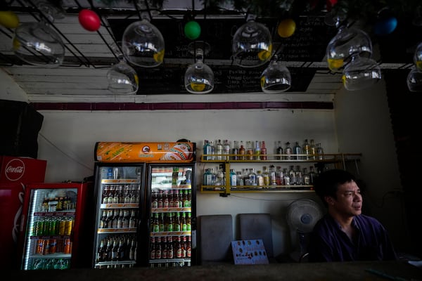 Duong Duc Toan, the manager of Nana Backpack hostel sits in the bar of the hostel in Vang Vieng, Laos, Tuesday, Nov. 19, 2024. (AP Photo/Anupam Nath)