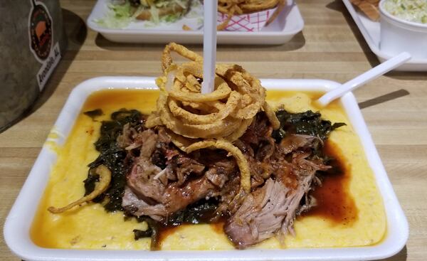 The pork n’ greens at Saw’s Soul Kitchen is served over creamy grits and topped with crispy fried onions. Wesley K.H. Teo