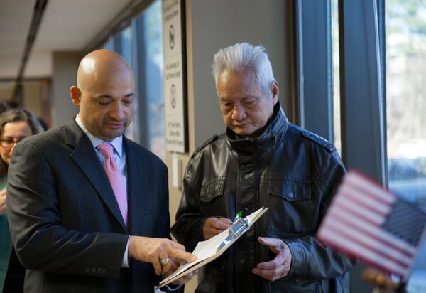 GALEO Executive Director Jerry Gonzalez, left, helps Voeung Trung, from Cambodia, fill out a voter registration form.