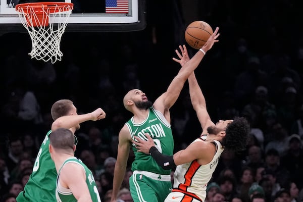 Boston Celtics guard Derrick White (9) blocks a shot by Detroit Pistons guard Cade Cunningham, right, during the first half of an NBA basketball game, Wednesday, Dec. 4, 2024, in Boston. (AP Photo/Charles Krupa)