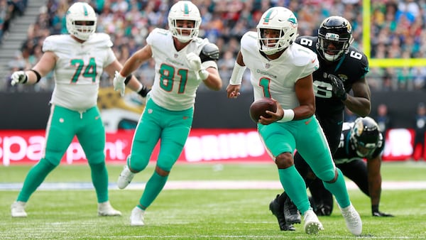 Miami Dolphins quarterback Tua Tagovailoa (1) runs with the ball against the Jacksonville Jaguars Sunday, Oct. 17, 2021, at the Tottenham Hotspur stadium in London, England. The Jaguars won 23-20. (Ian Walton/AP)