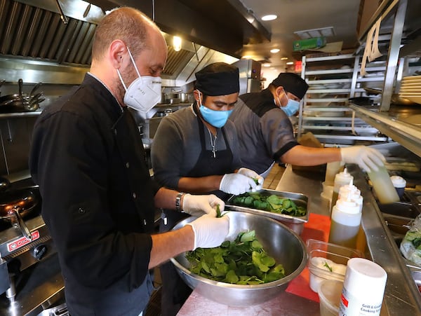 Chef/owner Ricardo Ullio (from left) Humberto Cruz and Guzmaro Narciso prepare meals at his Inman Park restaurant Sotto Sotto on Thursday, May 28, 2020, in Atlanta. CURTIS COMPTON CCOMPTON@AJC.COM