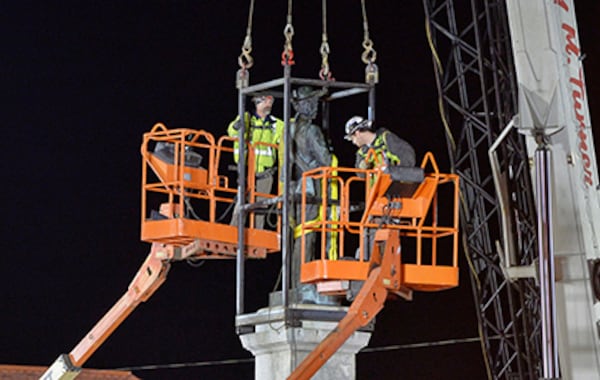 Workers prepare to remove a Confederate statue from its granite pedestal by the Chatham County Courthouse in Pittsboro, N.C., early Wednesday.