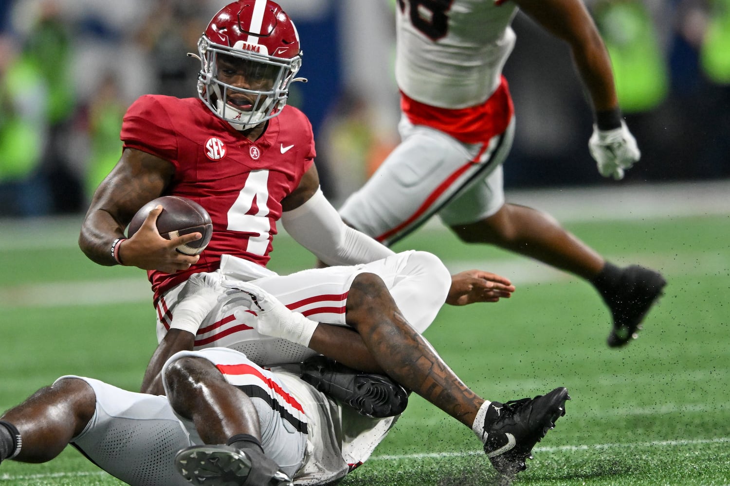 Alabama Crimson Tide quarterback Jalen Milroe (4) is tackled by Georgia Bulldogs linebacker Jalon Walker (11) during the first half of the SEC Championship football game at the Mercedes-Benz Stadium in Atlanta, on Saturday, December 2, 2023. (Hyosub Shin / Hyosub.Shin@ajc.com)