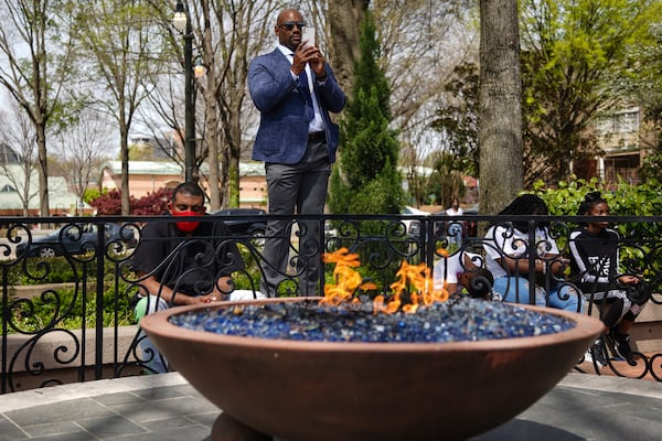 People listen to a speaker as the eternal flame burns at a wreath laying ceremony at The King Center on the 54th anniversary of the assassination of Dr. Martin Luther King Jr., on Monday, April 4, 2022, in Atlanta. (Elijah Nouvelage/Special to the Atlanta Journal-Constitution)