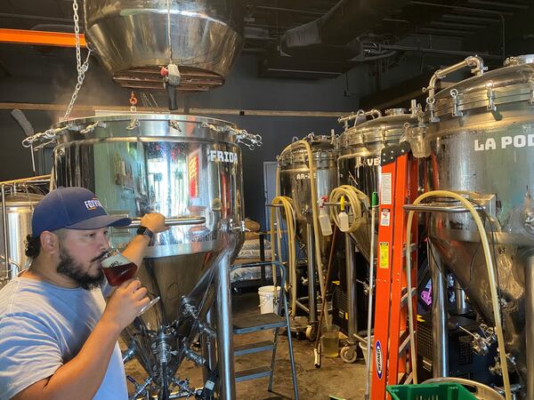 Owner and brewer Jonathan Martinez samples a new Vienna lager in the brewhouse at Indio Brewing in Sugar Hill. (Bob Townsend for The Atlanta Journal-Constitution)