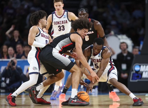 Gonzaga forward Emmanuel Innocenti, right,, and Georgia forward Asa Newell, center, go after a loose ball during the first half in the first round of the NCAA college basketball tournament, Thursday, March 20, 2025, in Wichita, Kan. (AP Photo/Travis Heying)