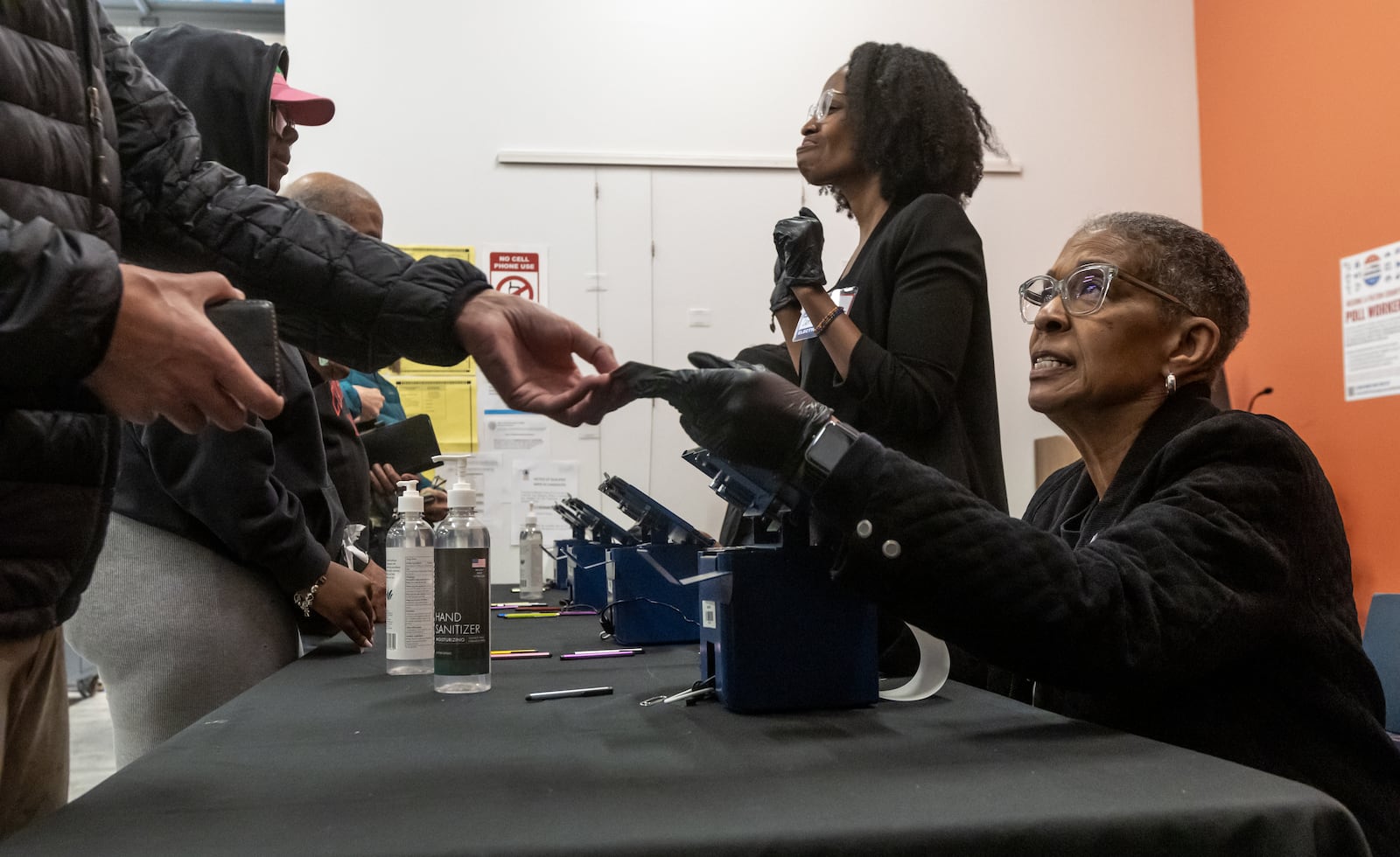 Poll worker Peggy Sherman (right)  checks in voters at the Joan P. Garner Library in Atlanta on Tuesday.