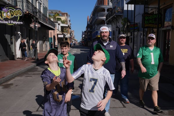 Cory Hunter throws a coin in the air on Bourbon Street, Thursday, Jan. 2, 2025 in New Orleans. (AP Photo/George Walker IV)