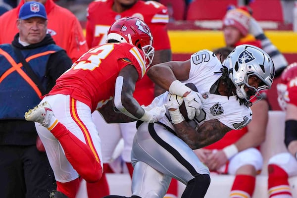 Las Vegas Raiders wide receiver Jakobi Meyers (16) is pushed out-of-bounds after a catch by Kansas City Chiefs linebacker Drue Tranquill (23) during the first half of an NFL football game in Kansas City, Mo., Friday, Nov. 29, 2024. (AP Photo/Charlie Riedel)