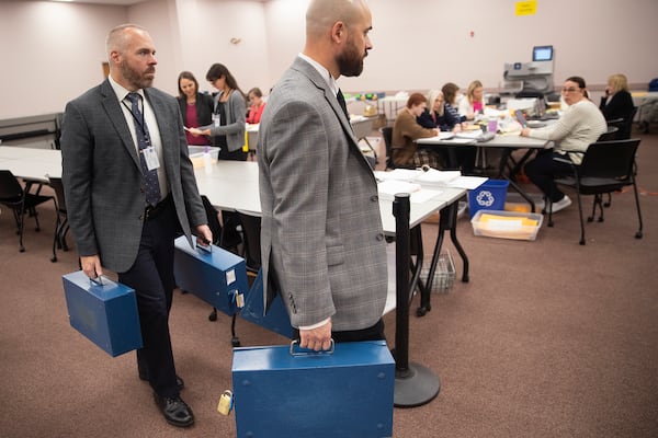 FILE - Detectives Dustin Tierney and David Silk, right, of the Department of the Secretary of State carry ballot boxes into the tabulation room on Thursday, Nov. 14, 2024 in Augusta, Maine. (Derek Davis/Portland Press Herald via AP, File)