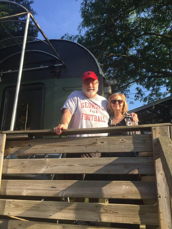 Bill and Leslie King on the platform of a dining car at The Station in Carrboro, N.C., that may be the “Valdosta,” on which they had their first big date in Athens in 1974. CONTRIBUTED BY OLIVIA KING