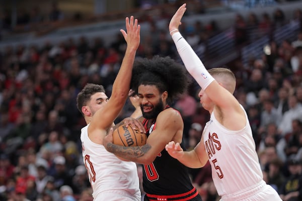 Cleveland Cavaliers forward Georges Niang, left, fouls Chicago Bulls guard Coby White, center, during an NBA basketball game Monday, Nov. 11, 2024, in Chicago. (AP Photo/Melissa Tamez)