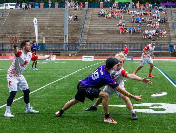 John Stubbs (center), #19, a player for the Hustle, Atlanta's American Ultimate Disc League team, passes around Philadelphia at St. Pius X High School Field on Saturday, June 26, 2021. Atlanta won the game 24-17.  (Jenni Girtman for The Atlanta Journal-Constitution)